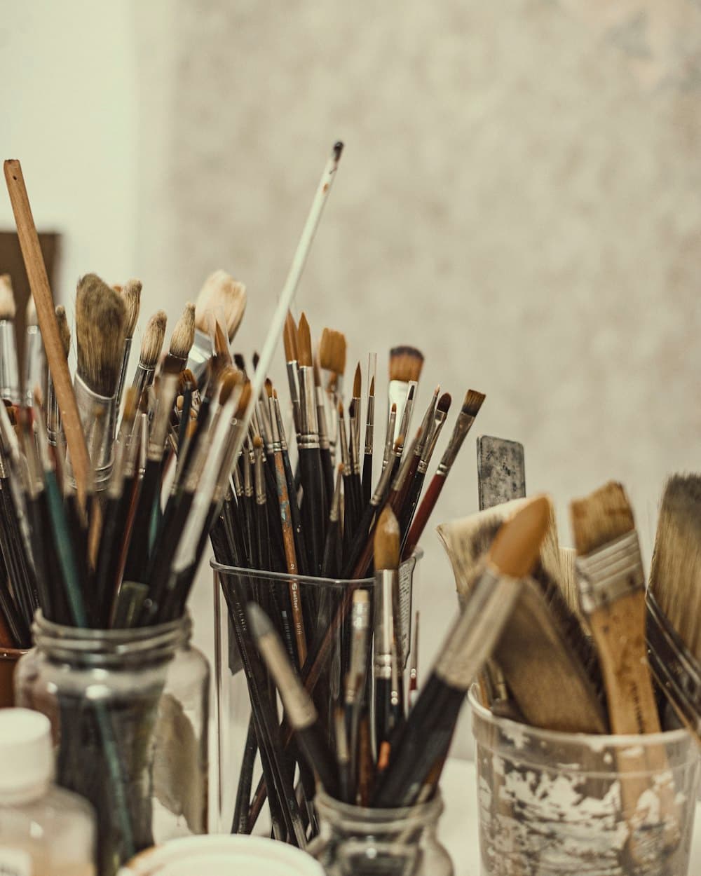 Jars crowded with well-used paint brushes