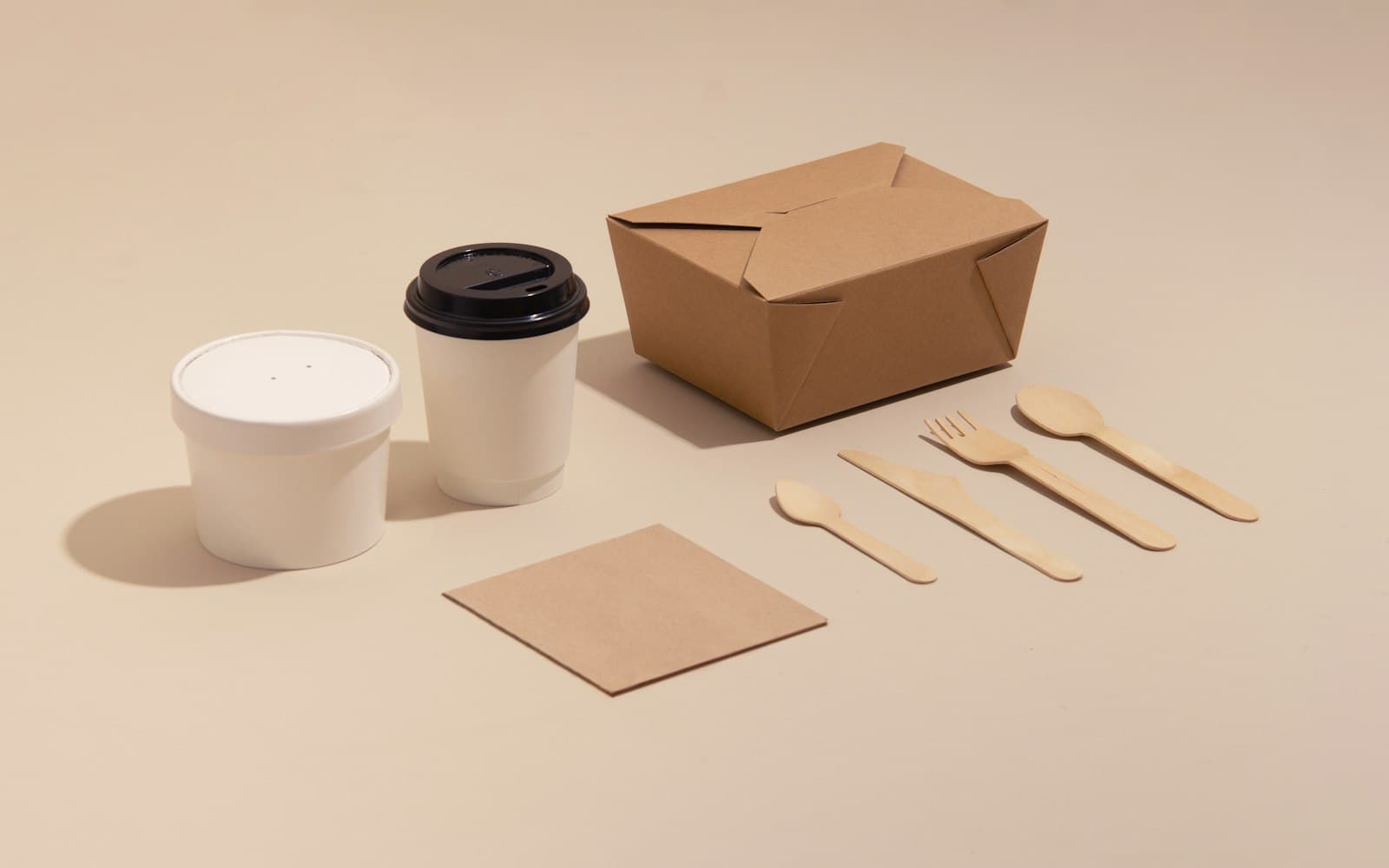 An unbranded kraft food box, paper cups and wooden cutlery