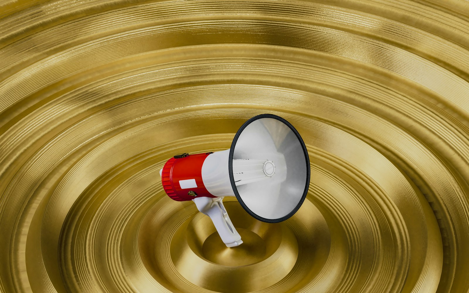 A red and white megaphone at the centre of rippling gold rings