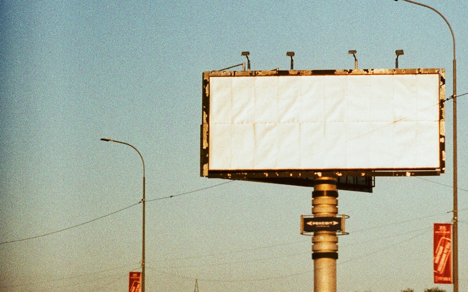 A blank roadside billboard against an evening sky