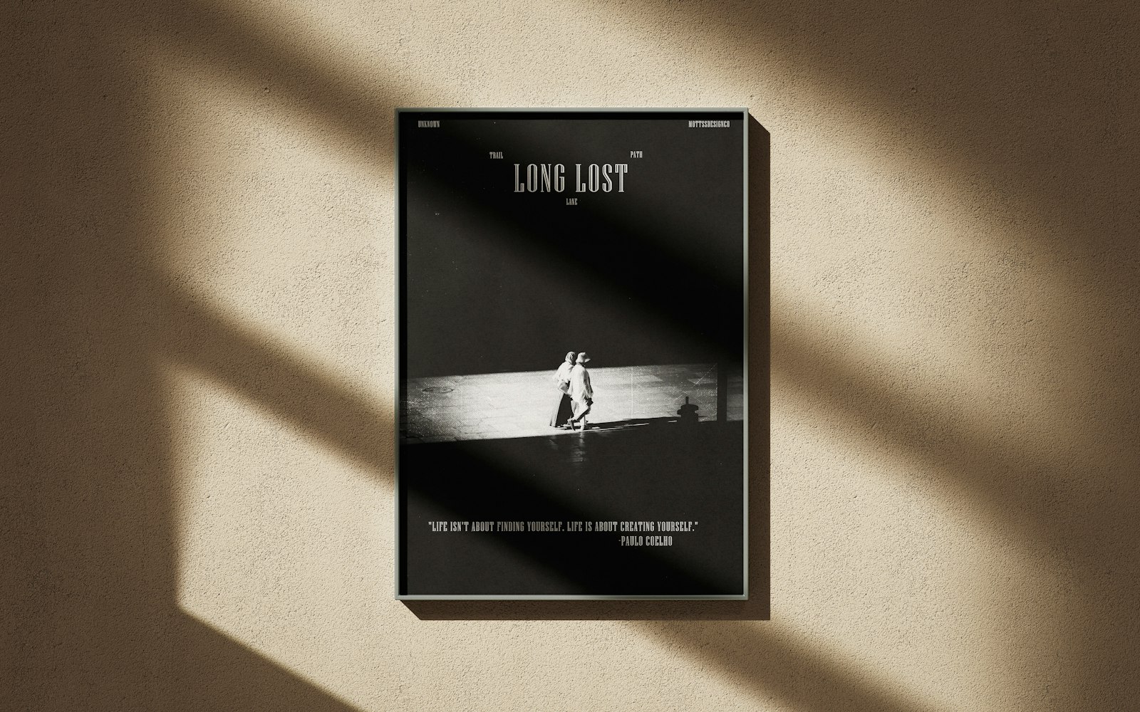 A framed black-and-white poster on a sunlit plaster wall